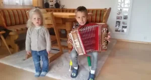 Young accordion player, Sibling bond through music, Children's musical talent, Accordion music magic, Dance inspired by music, Kids and musical instruments, Childhood musical moments, Family music stories, Magical childhood memories, Accordion melodies and dance