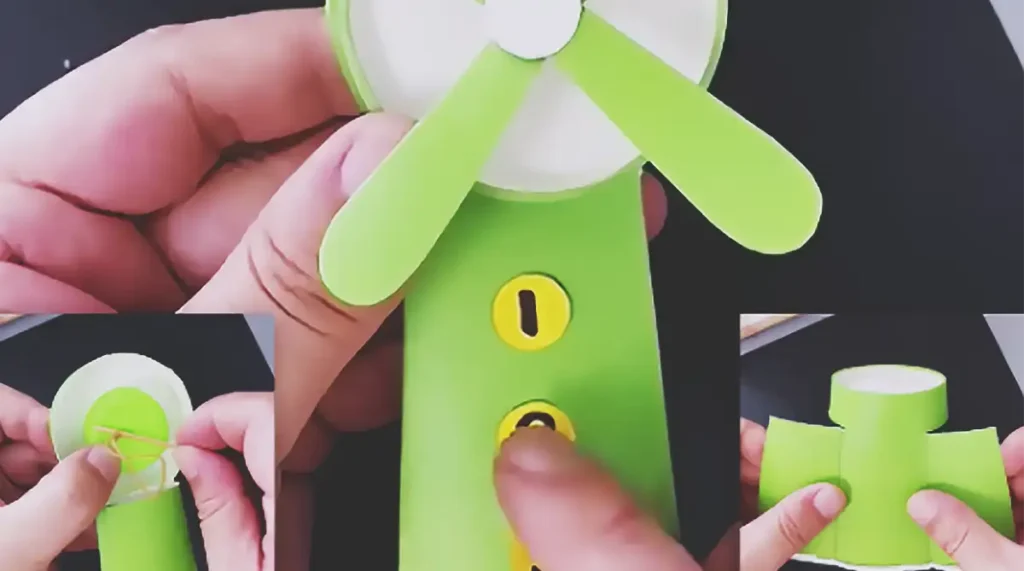 A green paper cup table fan craft with paper blades, a round center button, and numbered yellow stickers on the front, shown as a simple DIY summer craft for kids.