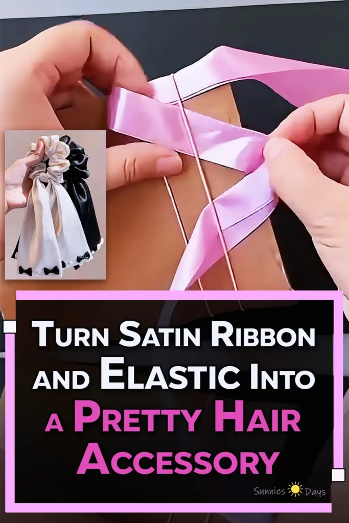 A handmade satin ribbon scrunchie hair tie with ruched pink ribbon, long ribbon tails, and a small gold charm, made using elastic bands and a cardboard frame.