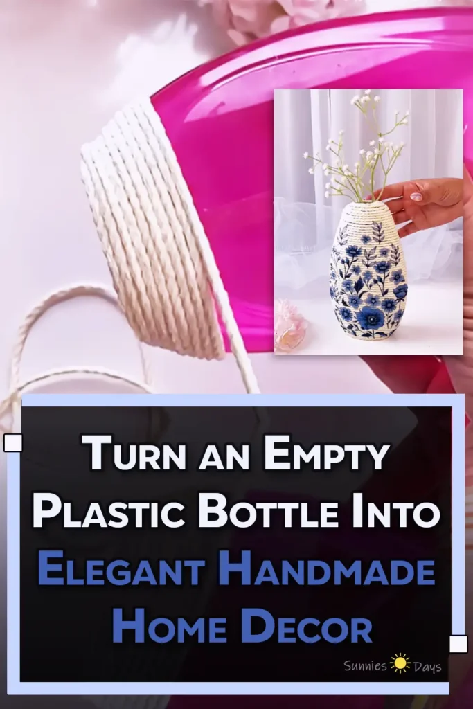 A handmade flower vase made from a recycled plastic bottle wrapped in cream rope and decorated with blue floral cutouts, holding small white flowers.