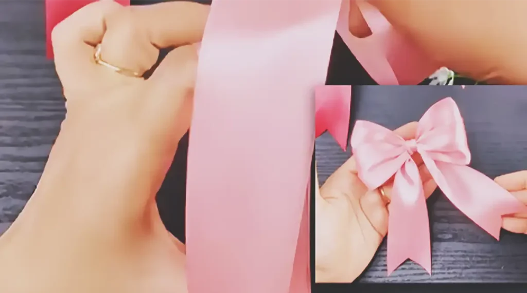 Hands demonstrating how to wrap wide pink satin ribbon around the fingers, tighten the center, shape two full loops, and cut the long tails into decorative V-shaped ends.