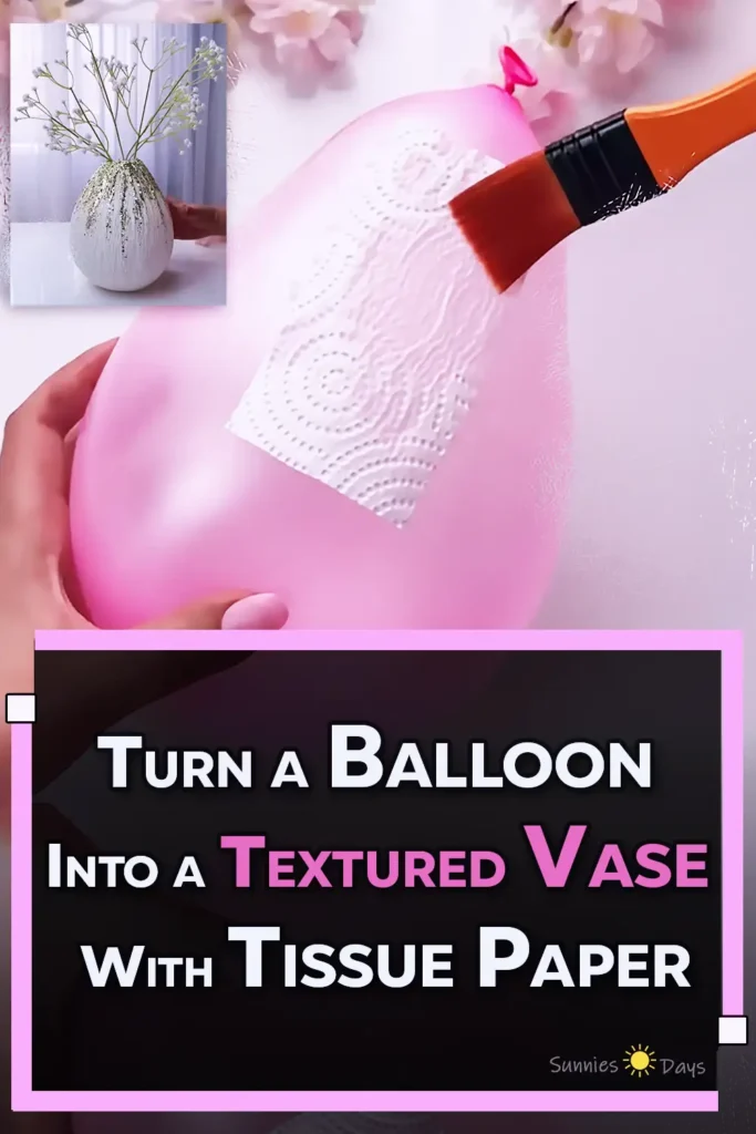 A finished white textured vase made by layering embossed tissue paper and glue over a balloon, decorated with cascading metallic glitter and filled with delicate white flower stems.